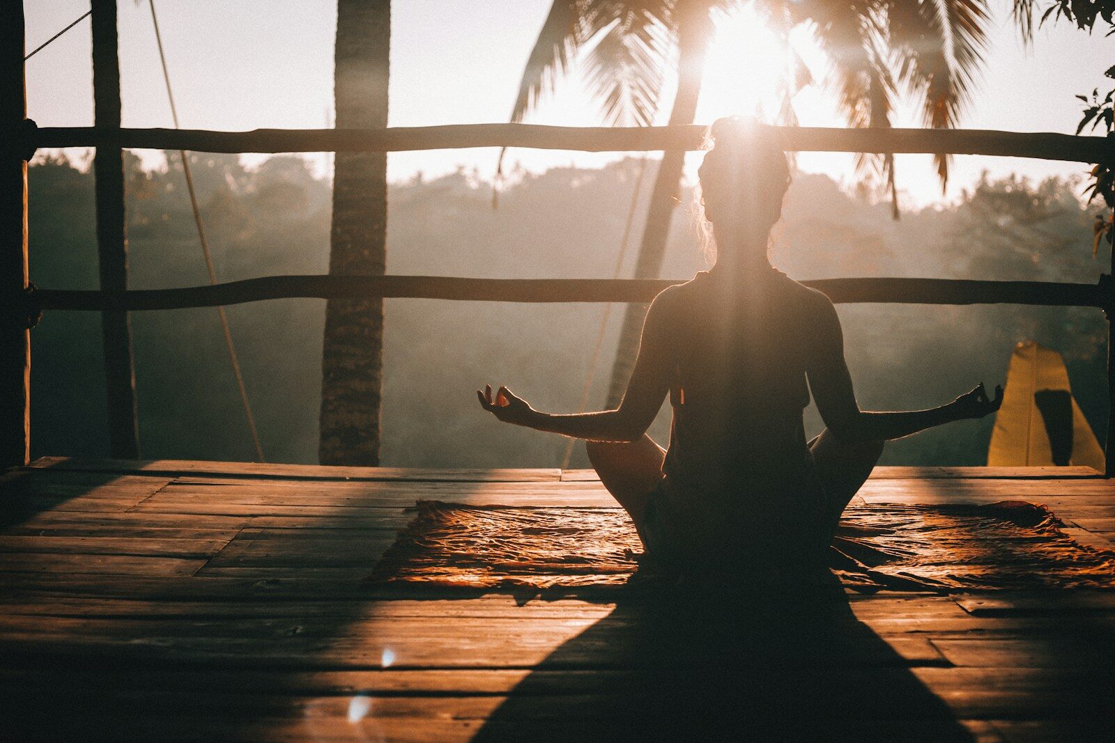 Woman in a calm seated yoga pose at dusk